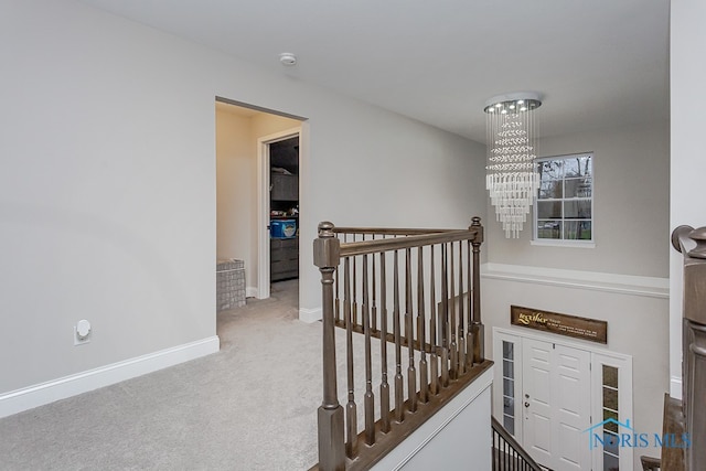 stairway with carpet flooring and an inviting chandelier