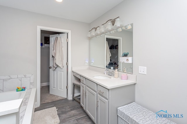 bathroom featuring hardwood / wood-style flooring, vanity, and a bath