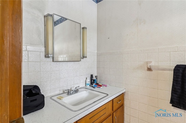 bathroom featuring vanity and tile walls