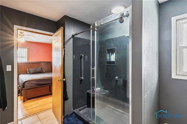 bathroom with hardwood / wood-style flooring, ceiling fan, and a shower with shower door