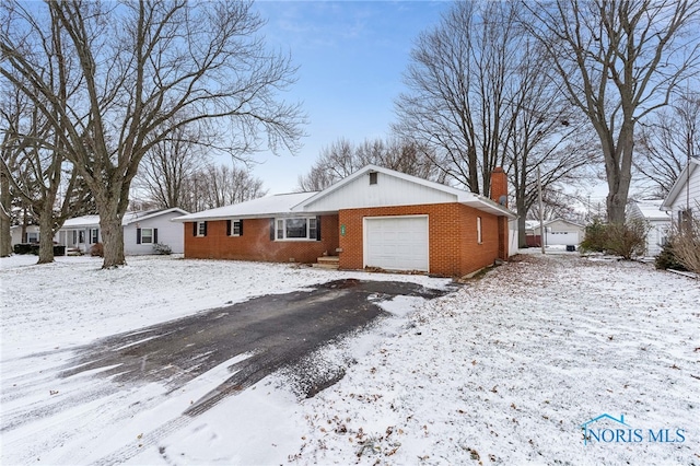 snow covered property with a garage