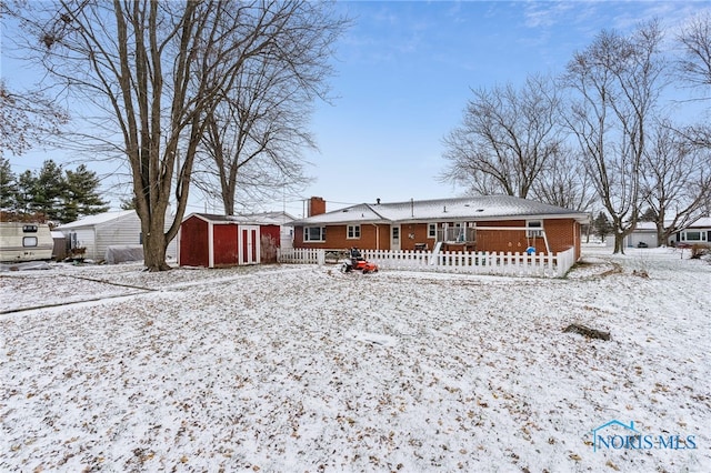 snow covered property featuring a storage unit