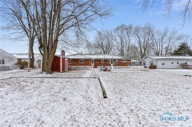 view of snow covered rear of property