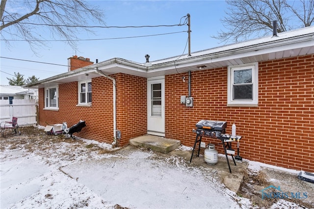 view of snow covered rear of property