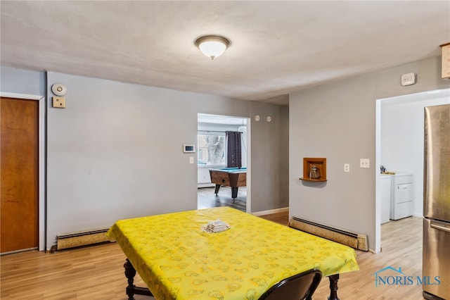 dining area with washer / dryer, light hardwood / wood-style floors, a baseboard heating unit, and billiards