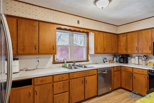 kitchen with sink, appliances with stainless steel finishes, and light hardwood / wood-style flooring