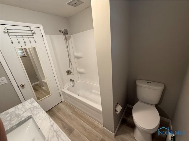 full bathroom with bathtub / shower combination, wood-type flooring, vanity, and toilet