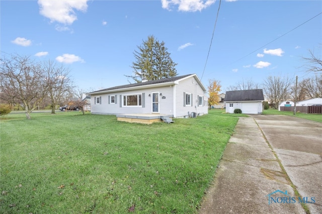 view of side of property with a lawn, a garage, and an outdoor structure