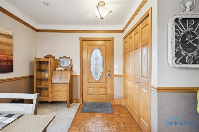 entryway with a healthy amount of sunlight, crown molding, and light parquet flooring