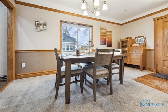 carpeted dining room featuring an inviting chandelier and ornamental molding