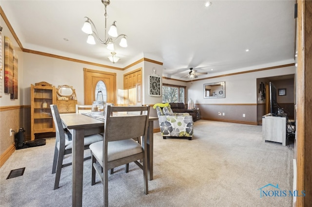 dining room featuring ceiling fan with notable chandelier, carpet floors, and ornamental molding