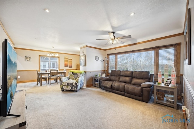 carpeted living room featuring a textured ceiling, ceiling fan with notable chandelier, and crown molding