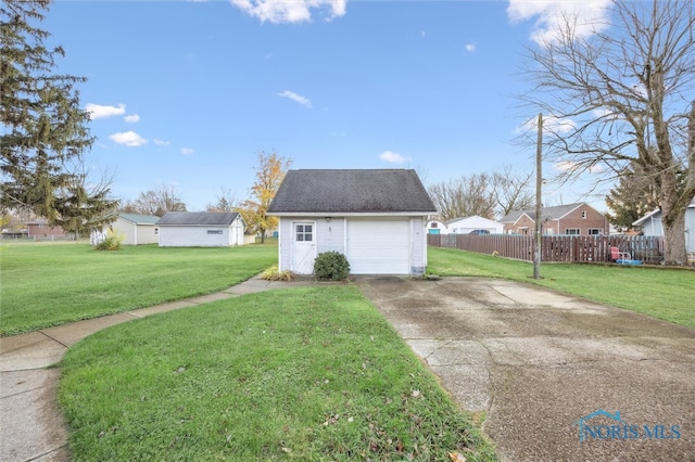 exterior space with a garage, an outbuilding, and a yard