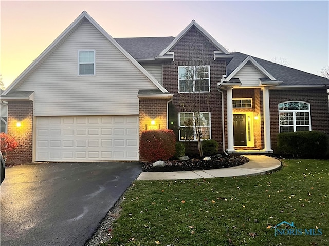 front of property featuring a yard and a garage