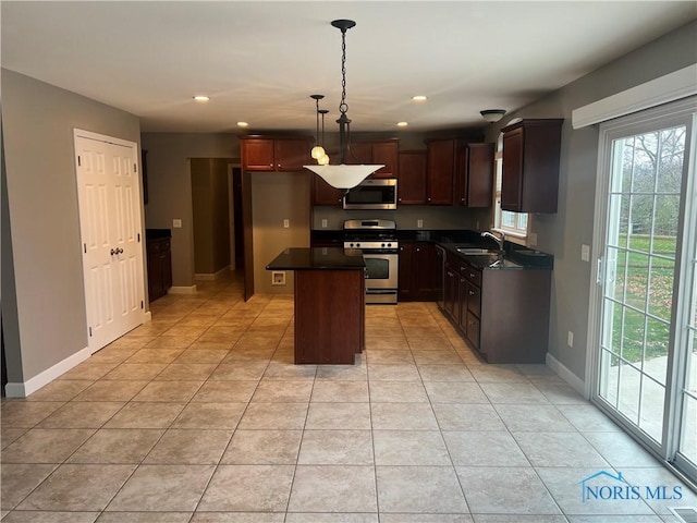 kitchen featuring pendant lighting, a center island, sink, light tile patterned floors, and appliances with stainless steel finishes