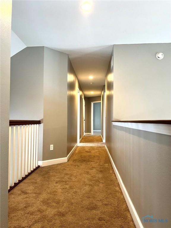 hall with lofted ceiling and carpet floors