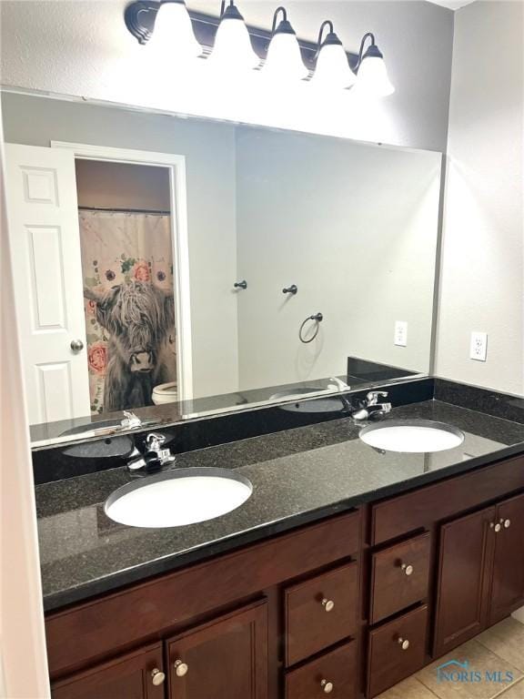 bathroom featuring tile patterned flooring, vanity, and toilet