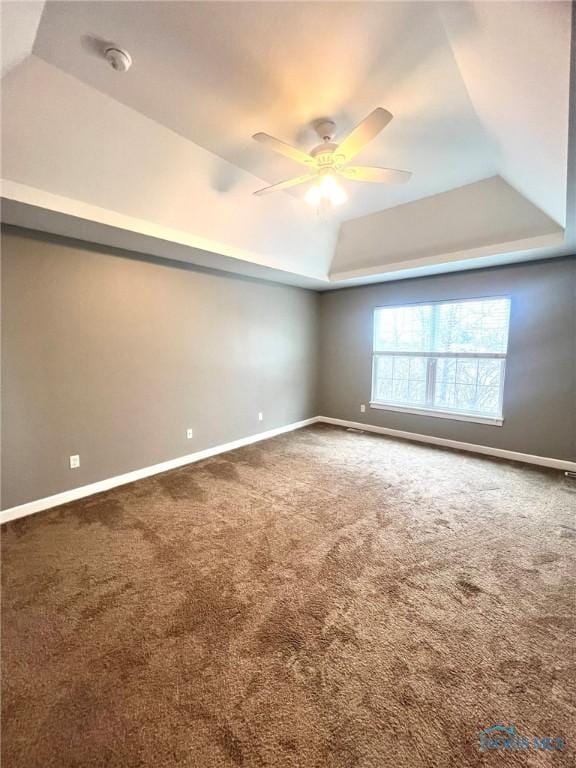 spare room with carpet, ceiling fan, and a tray ceiling