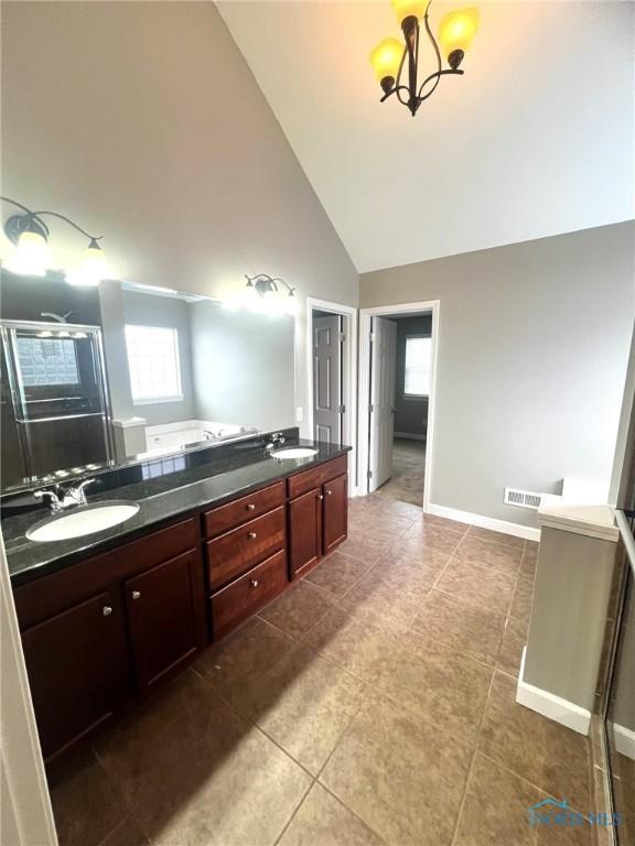 bathroom with a chandelier, high vaulted ceiling, vanity, independent shower and bath, and tile patterned flooring