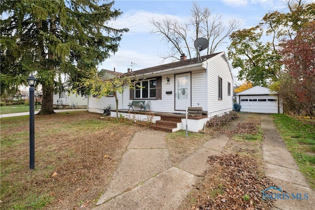 view of front of property featuring a garage, an outdoor structure, and a front lawn