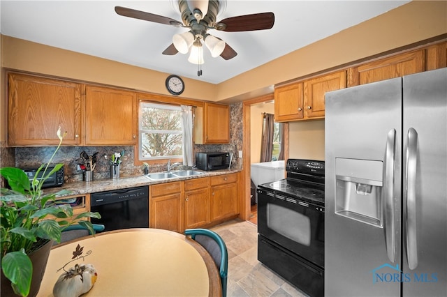 kitchen with light stone countertops, sink, ceiling fan, tasteful backsplash, and black appliances