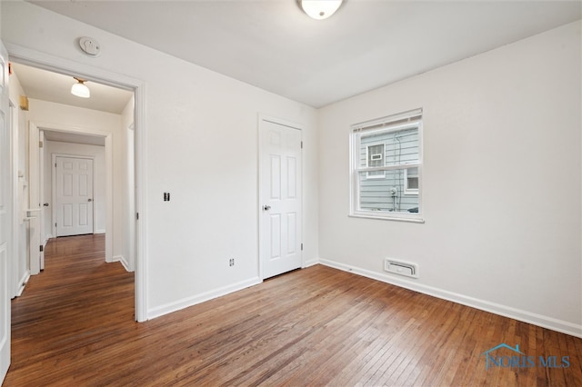 unfurnished bedroom with hardwood / wood-style flooring and a closet