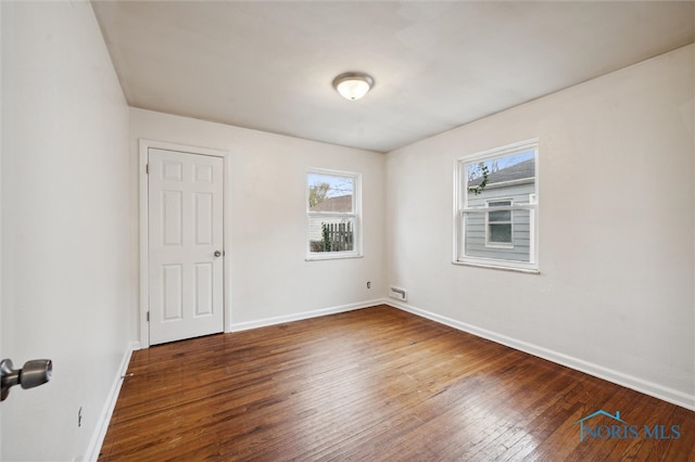 empty room with dark hardwood / wood-style flooring