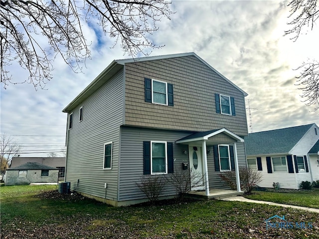 view of front of home featuring cooling unit and a front lawn