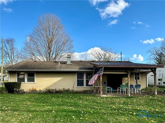 rear view of property with a lawn and a patio area