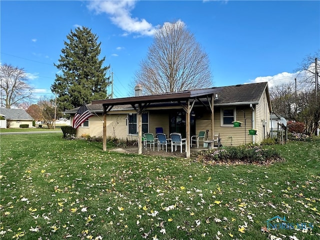 rear view of house with a patio area and a lawn