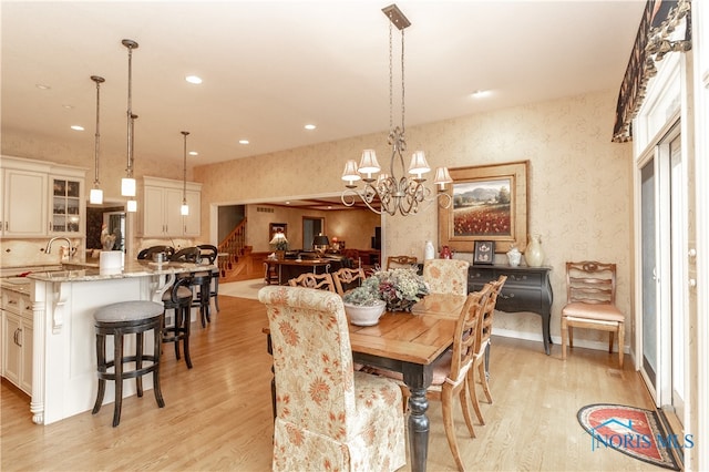 dining area with a chandelier and light hardwood / wood-style flooring