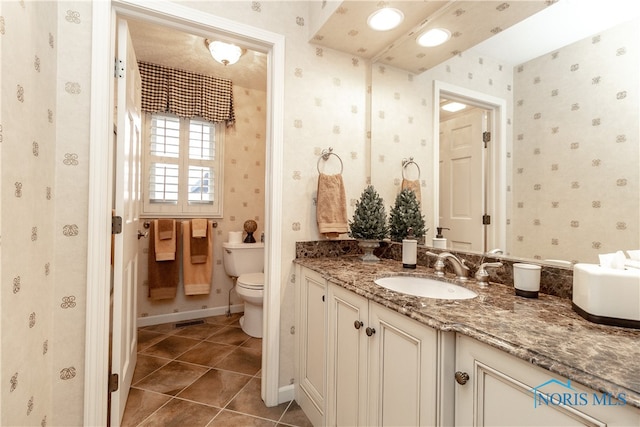 bathroom with tile patterned flooring, vanity, and toilet