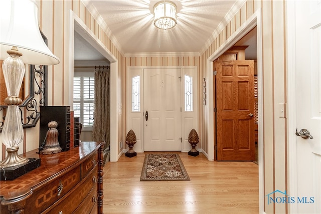 foyer entrance featuring ornamental molding and light hardwood / wood-style flooring