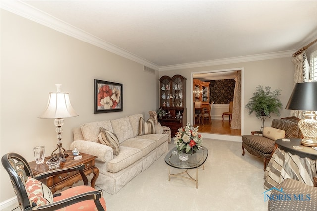 carpeted living room with ornamental molding