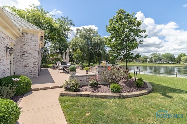 view of yard with a water view and a patio