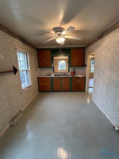 kitchen featuring ceiling fan, ornamental molding, and sink