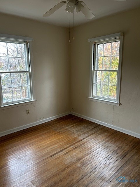 spare room featuring ceiling fan, a healthy amount of sunlight, and light hardwood / wood-style floors