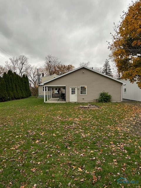 rear view of property with a yard and a patio area