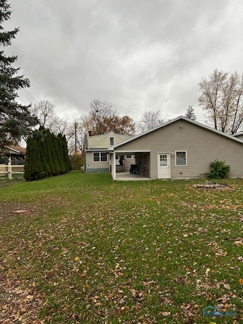 rear view of property with a lawn and a patio