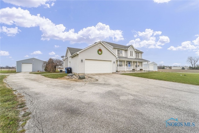 view of property with a front yard, a porch, and a garage