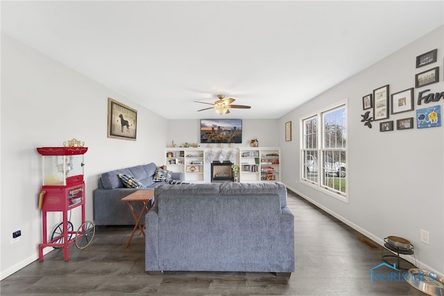 living room with ceiling fan and dark wood-type flooring