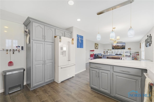 kitchen with gray cabinets, white fridge with ice dispenser, pendant lighting, and dark hardwood / wood-style floors