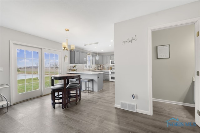 dining area featuring dark hardwood / wood-style flooring, a chandelier, and sink