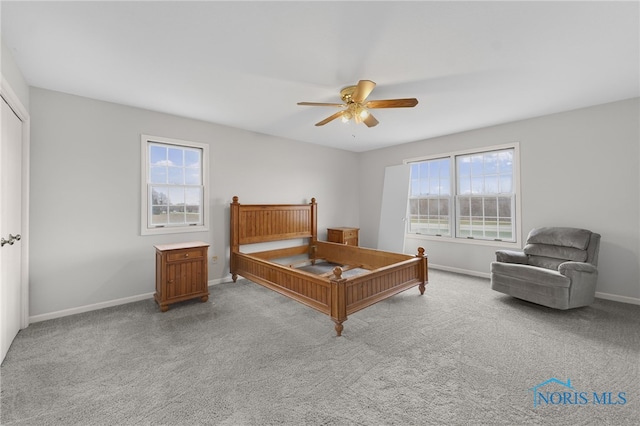 bedroom with ceiling fan, carpet floors, and multiple windows