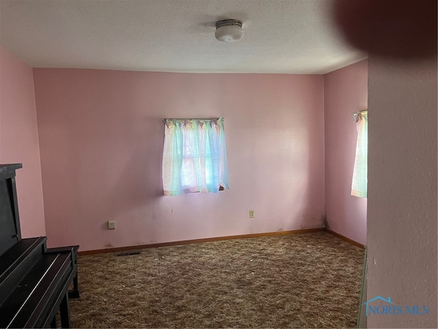 unfurnished living room with carpet and a textured ceiling