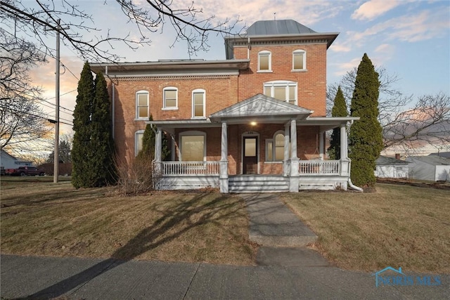 italianate-style house with a porch and a yard