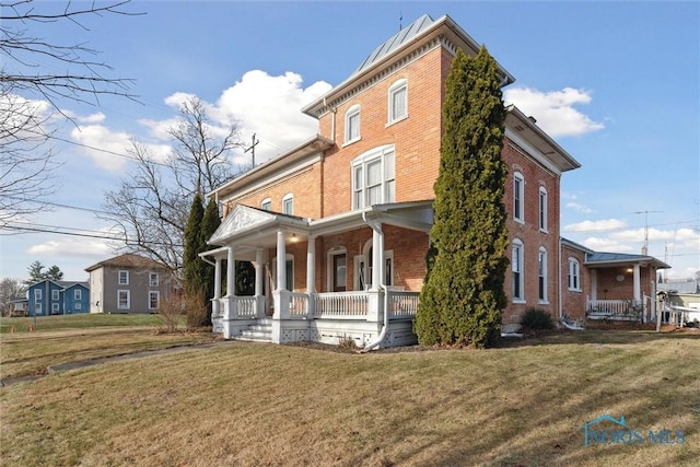 view of side of home featuring a yard and a porch