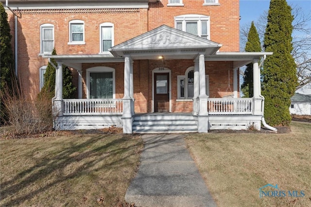 view of front of property with covered porch and a front yard