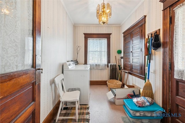 laundry area featuring washing machine and dryer, a chandelier, and ornamental molding