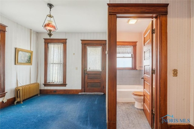 doorway featuring carpet flooring and radiator heating unit